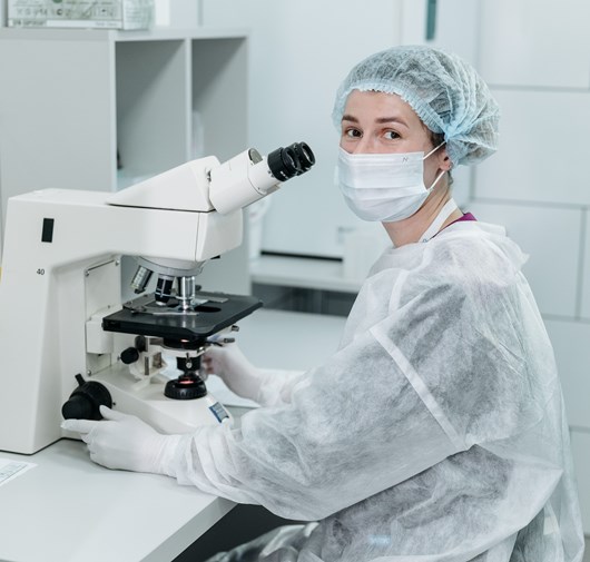 Technicienne de laboratoire Kum Concept illustrant l'engagement pour la sécurité, la maîtrise des contaminations et la fiabilité des mesures