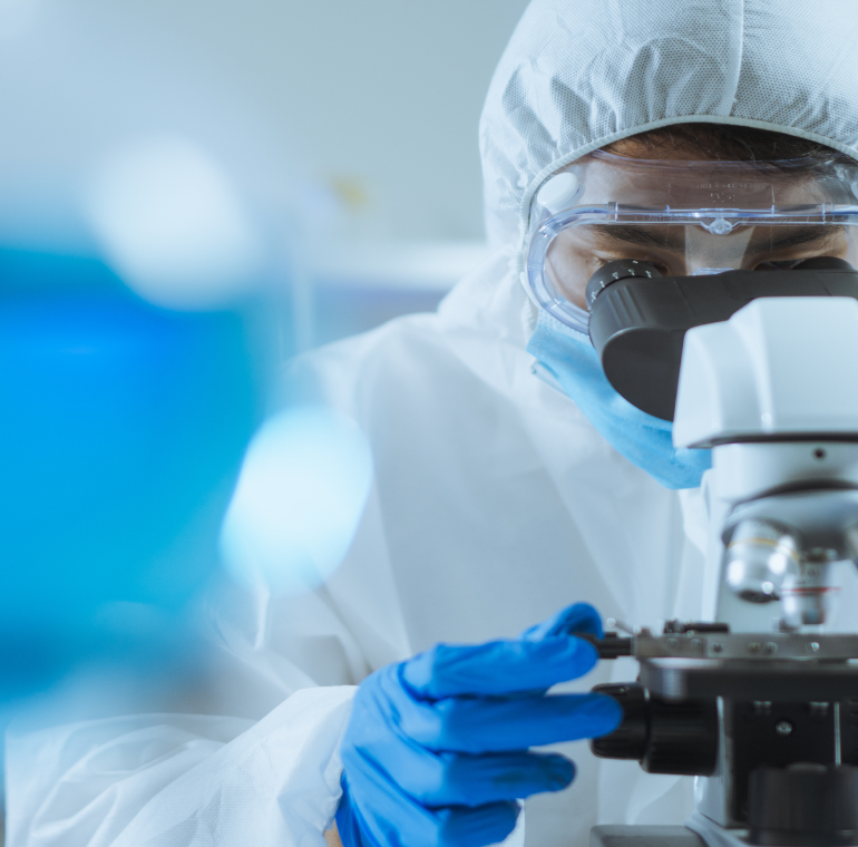 Technicien de laboratoire examinant un échantillon au microscope, illustration de la section "Pourquoi choisir Kum Concept ?"